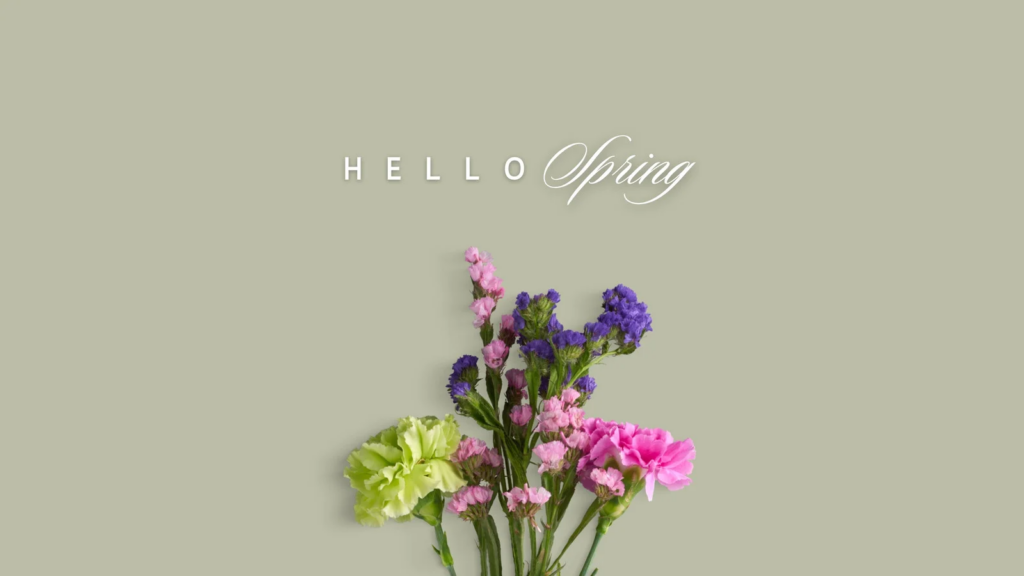 A small bouquet of spring flowers in pink, purple and green on a soft green background with the text ‘Hello Spring’ above.